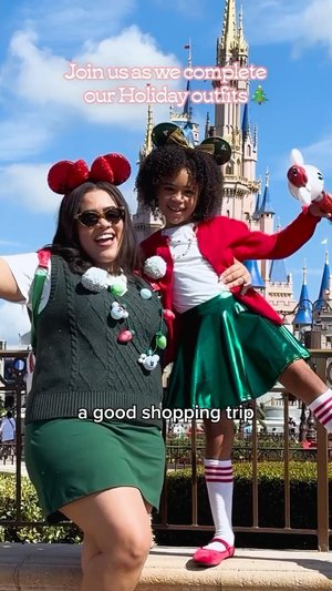 Two women celebrate holiday shopping at a theme park, wearing festive outfits and accessories, with a castle backdrop.